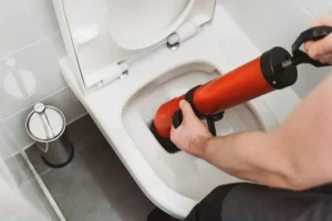 a drainage technician unblocking a toilet with specialist equipment